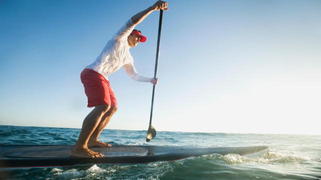 A person surfing wearing sustainable men's swim trunks