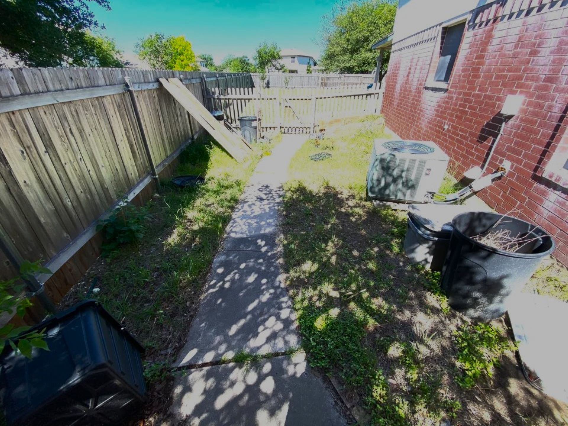 The before image showed a sparse, weedy strip of lawn running along a brick house.