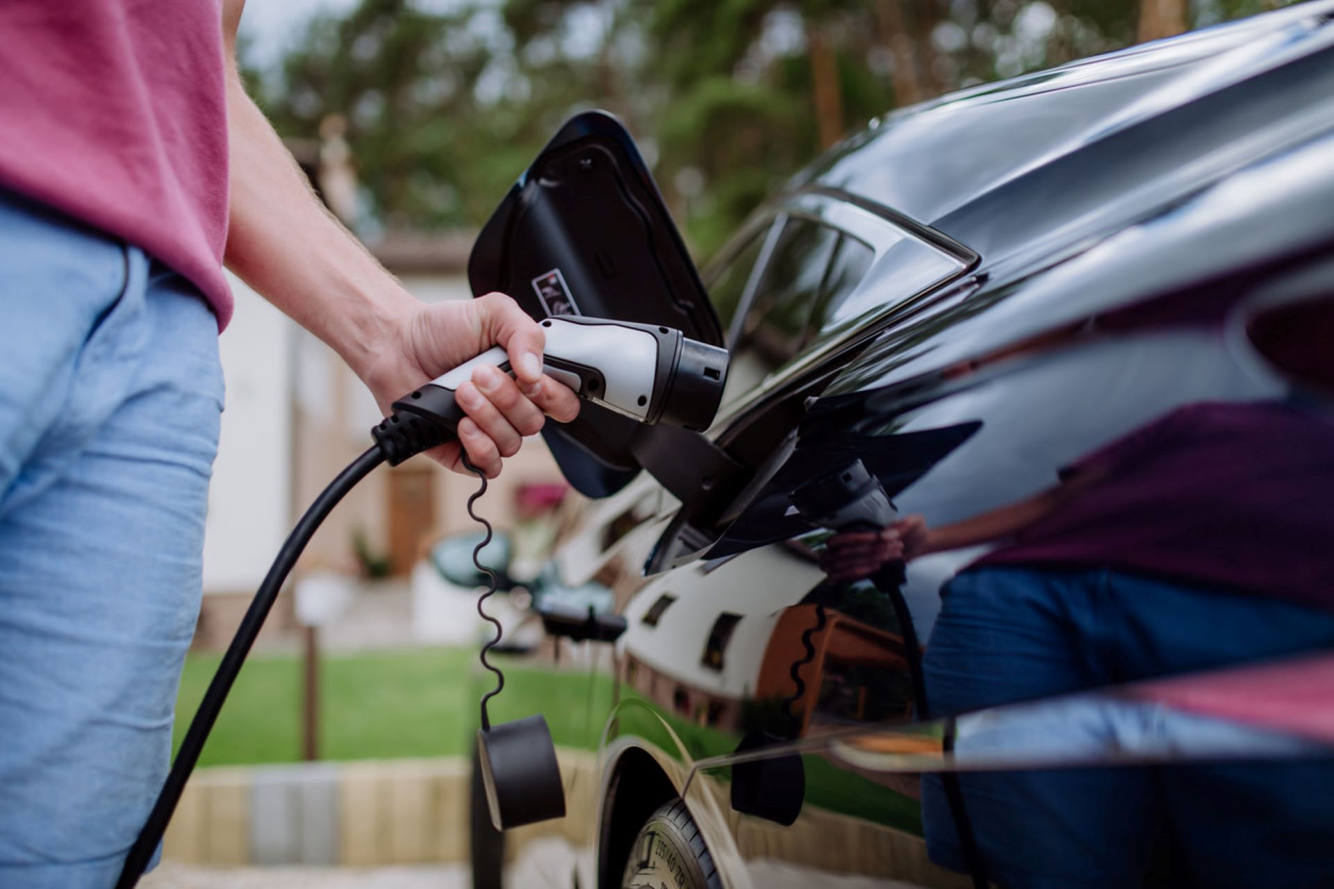 A person holding a charger in an electric vehicle.