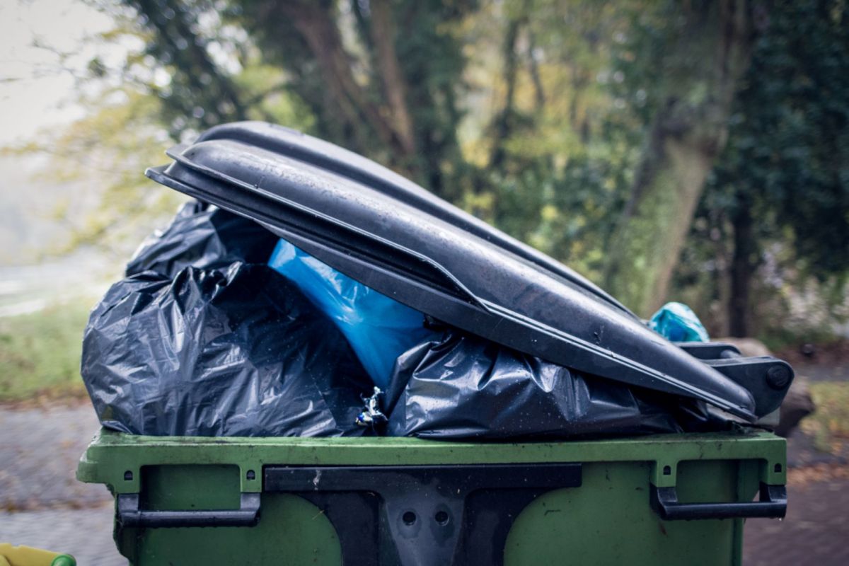 Garbage can with lid half open.