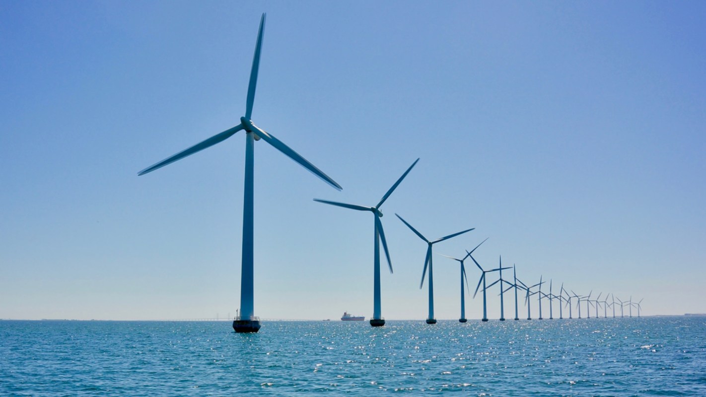 a row of wind turbines over the ocean