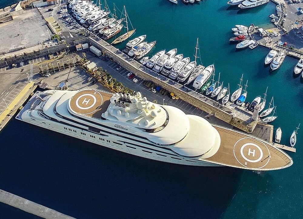 The yacht appears to be docked at a marina in a special area away from smaller boats.