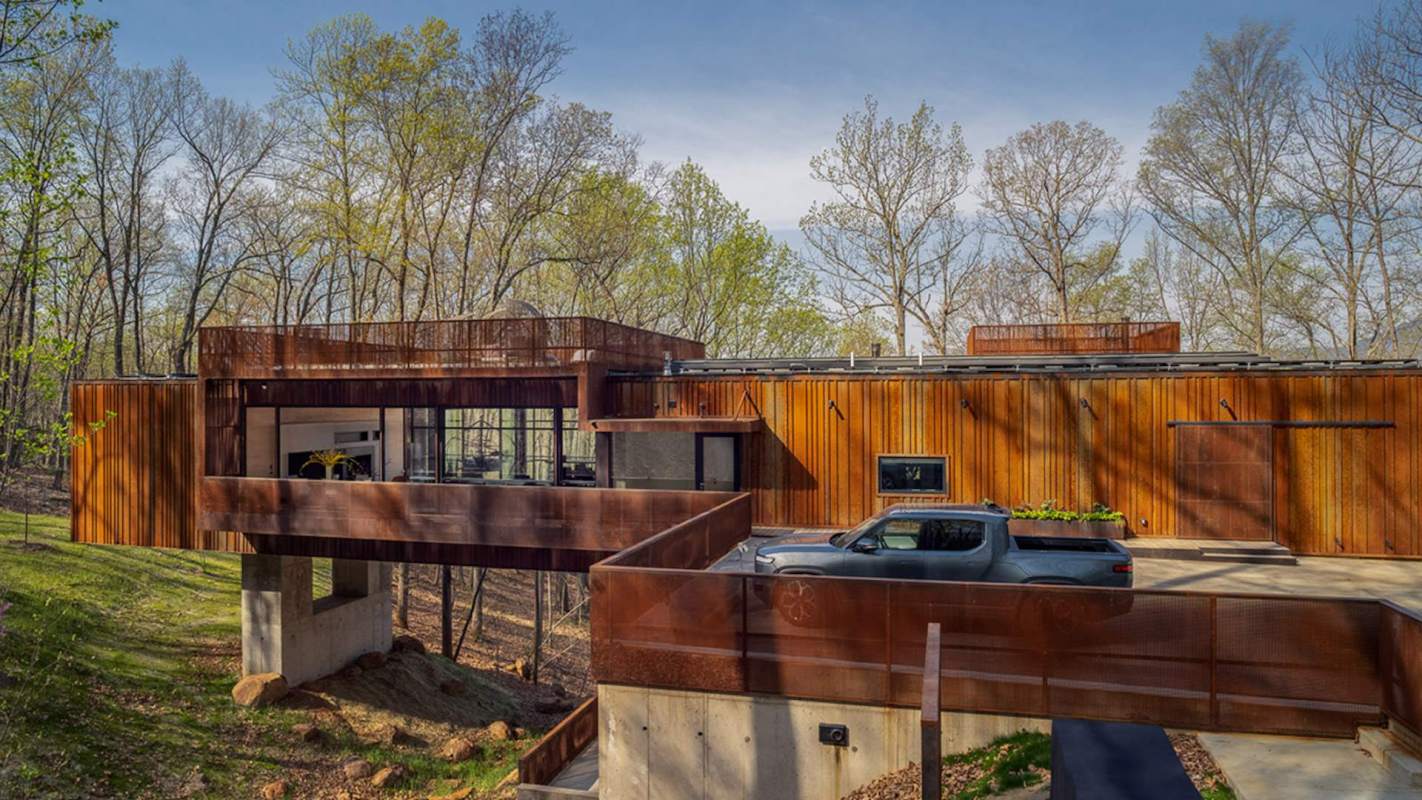 This modern home in Charlottesville, Virginia blends harmoniously with surrounding trees as if the house is floating in the woods.