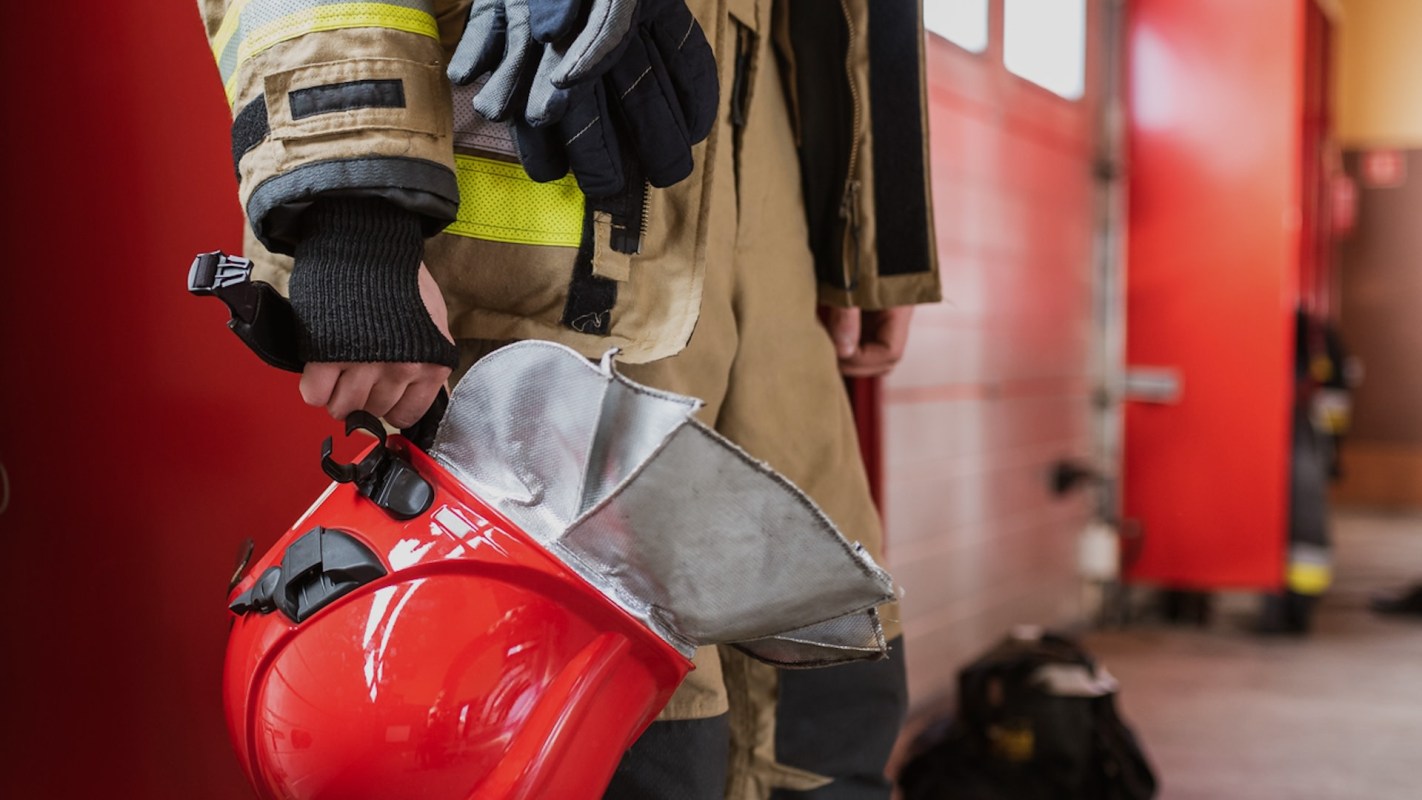 a firefighter holding their equipment